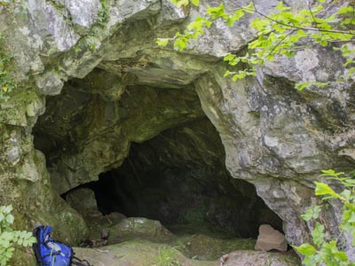 A cave with a hole in the rock
Description automatically generated