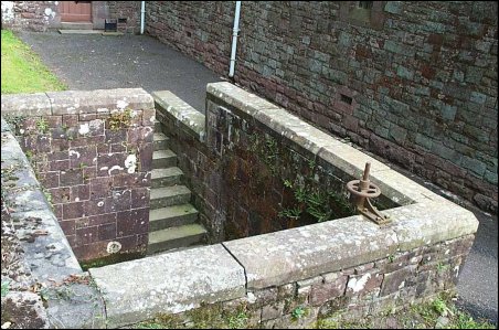 A stone wall with a hole in it
Description automatically generated